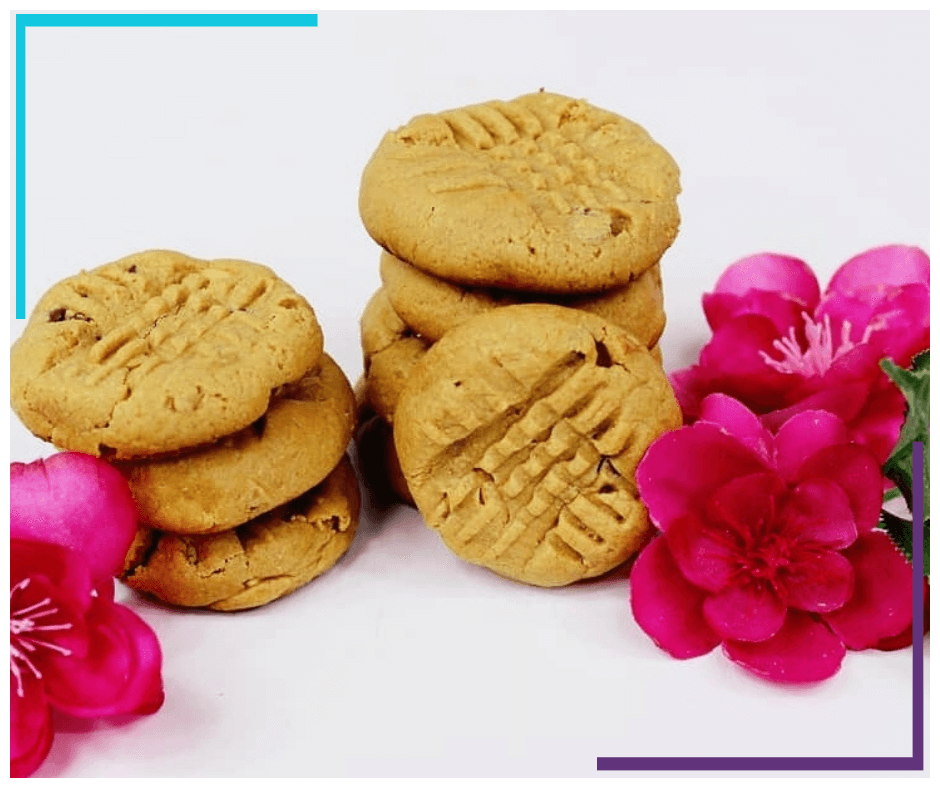 Two stacks of Peanut Butter Cookies sit on a white surface, decorated with pink flowers